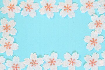 Cherry blossom petals paper crafts on light blue background for wall paper.  Blank for copy space.