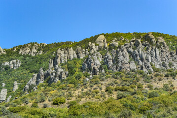 Ancient limestone high mountains of rounded shape in the air haze. The Valley of Ghosts. Demerji. May 2021. Crimea. Russia.