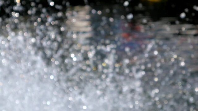 Water Drops and Bokeh Lights of splashing water. The paddle wheels of aerator hit water spread into the air and reflected the sun light. 
Working waste water treatment machine. slow motion, defocused.