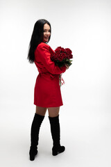 Beautiful brunette holding a bouquet of red roses