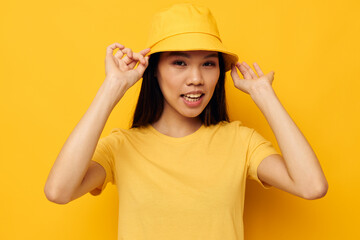 Charming young Asian woman in a yellow t-shirt and hat posing emotions Lifestyle unaltered