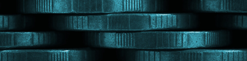 Stacks of coins closeup. Money textured banner. Dark blue tinted headline made of many coin edges. Russian tens. Economy finance and budget. Macro