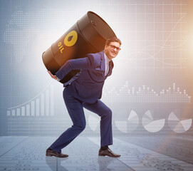 Businessman under the burden of oil barrel