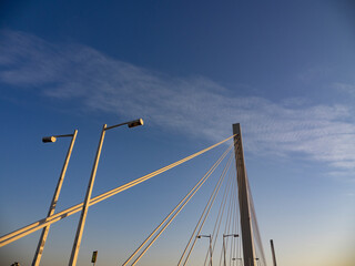 Obraz premium 夕陽に照られた吊橋の柱とワイヤーと街灯