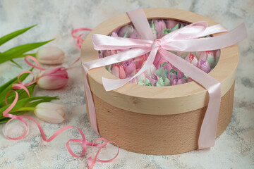 Handmade marshmallows in wooden packages on a light background with flowers. The concept of the holidays Women's Day and Valentine's Day.