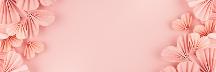 Tender  romantic Valentine day banner - pink hearts of chinese paper fans flying on pastel pink background, sideways border, top view, copy space.