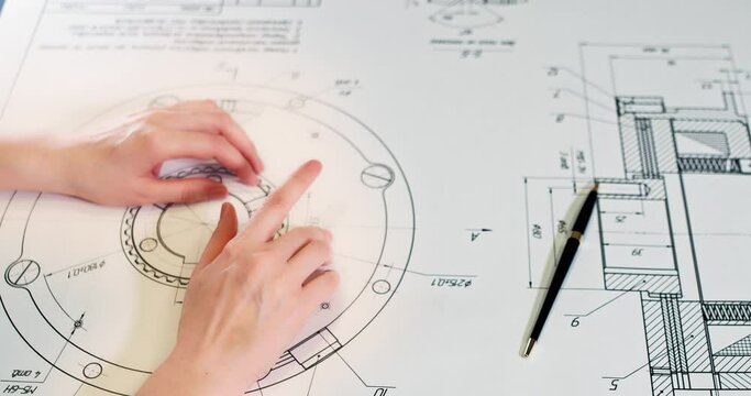 Real estate, construction, construction, architecture. An engineer-architect shows a draft plan of a project for the construction of a residential building.