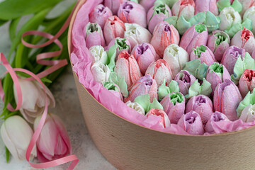 Handmade marshmallows in wooden packages on a light background with flowers. The concept of the holidays Women's Day and Valentine's Day.