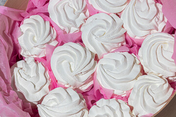 Handmade marshmallows in wooden packages on a light background with flowers. The concept of the holidays Women's Day and Valentine's Day.