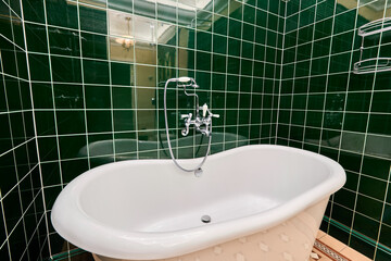 Beautiful cozy luxury bathroom with green tiles 