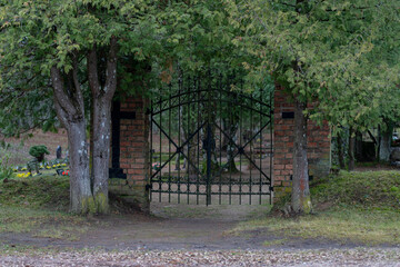 cemetery gate, columns made of red bricks, door made od cast iron.