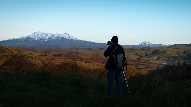 Photographer taking photos of Mt Ruapehu and Mt Ngauruhoe at sunrise
