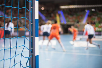 Detail of handball goal post with net and penalty shot in the background.
