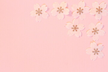 Cherry blossom petals paper crafts on pink textured paper background for wall paper.  Blank for copy space.