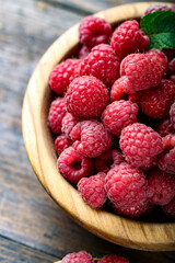 Fresh raspberry in a wooden plate.
