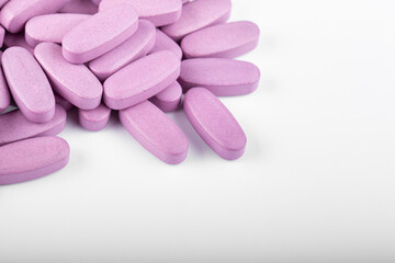 Obraz na płótnie Canvas Purple pills on a white background. Global health care concept. Antibiotics drug resistance.