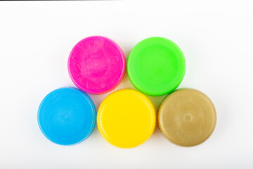 Pile of colored plastic caps on white background. Recycling concept.