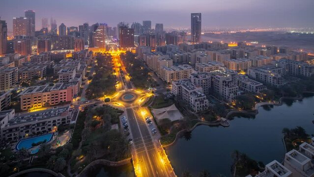 Skyscrapers in Barsha Heights district and low rise buildings in Greens district aerial night to day timelapse.