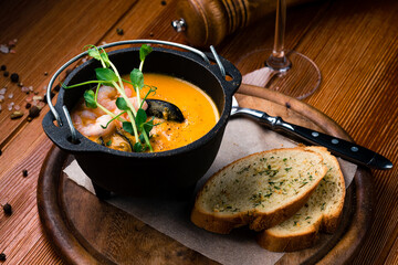 Seafood cream soup with shrimps In black plate Top view, copy space.