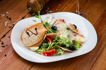 Salad with cherry tomatoes, ham, croutons, lettuce, grated cheese