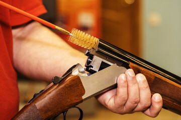 The process of cleaning a shotgun with a plastic brush. Caring for firearms with special tools....