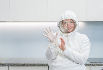 Woman fooling around at home during coronavirus quarantine, dressed up in a funny protective suit...