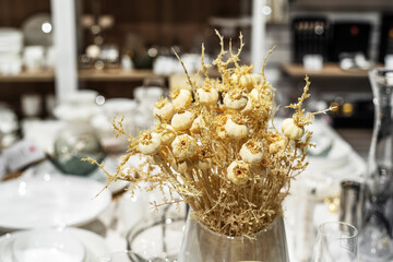 Artificial heads of garlic in a glass vase. Decorating kitchens with dry plants and flowers. Foreground. Selective focus
