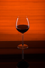 glass goblet of red wine on a red background