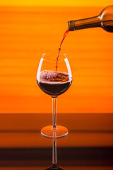 glass goblet of red wine on an orange background