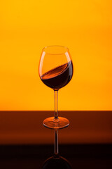 glass goblet of red wine on an orange background