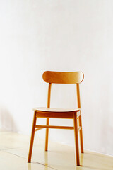 Wooden chair in retro style on a white wall background. Vertical photo
