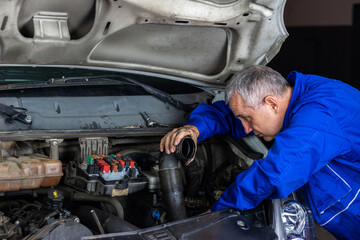 Senior experienced mechanic repairing a car