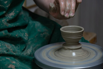 Potter at work. Hands of potter do a clay pot