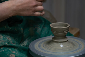 Potter at work. Hands of potter do a clay pot