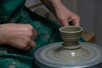 Potter at work. Hands of potter do a clay pot