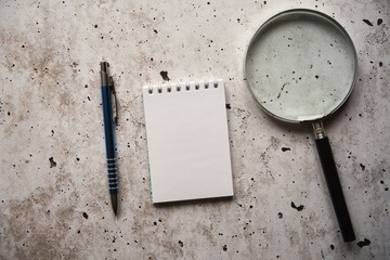 notes, lupa i długopis na betonowym stole - obrazy, fototapety, plakaty
