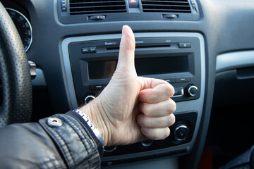 Closeup of men hand showing thumbs up in the car