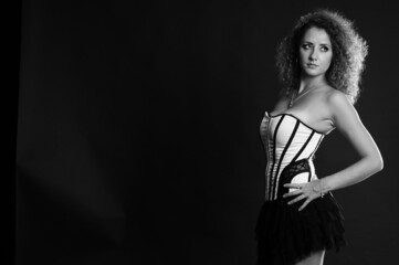 Obraz na płótnie Canvas curly-haired girl in a seductive corset posing 