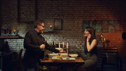 Stay at home and order food online - Couple having romantic dinner in home quarantine, eating from takeaway box and drinking red wine.