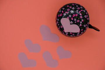 Bicycle bell in floral pattern and hearts on Koral color background. Copy space.  © Ganna Zelinska