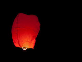 Red Thai sky lantern in mid-air during Loi Krathong