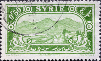 Syria - circa 1925: A postage stamp from Syria shows a landscape with mountains and sailing boats in the foreground