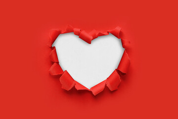 A paper hole with torn edges on a red background. Through paper. A ragged hole in the shape of a heart. Valentine's day. A symbol of love, romantic relationships. International Women's Day. - obrazy, fototapety, plakaty