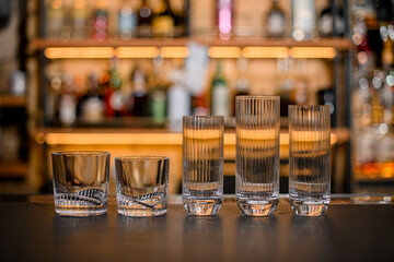 group of drink glasses of different sizes on blurred background