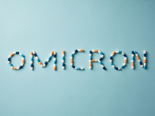 Word Omicron made of colorful pills and capsules