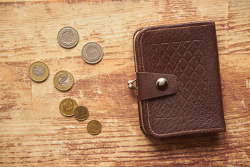 monety i brązowy portfel na drewnianym stole,polski złoty  - obrazy, fototapety, plakaty