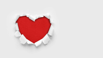 Naklejka na ściany i meble A paper hole with torn edges on a white background. Through paper. A ragged hole in the shape of a heart. Valentine's day. A symbol of love, romantic relationships. International Women's Day.