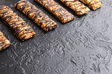 Tasty chocolate nut bars on dark background