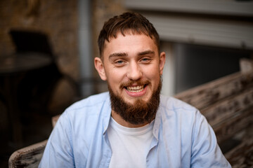 Obraz premium portrait of smiling man with a beard in shirt on a blurred background