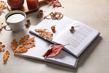 Books, cup of coffee, accessories and autumn decor on light background